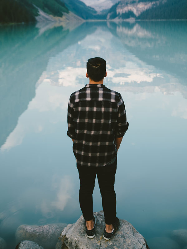 Man looking at a lake.